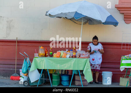 Femme lisant au stand de nourriture dans la rue, Oaxaca, Mexique Banque D'Images