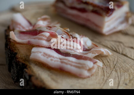 Délicieux ensemble artisanale dalle fumé bacon sur un bloc de coupe Banque D'Images