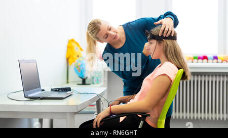 Jeune adolescente et thérapeute pour enfants au cours de l'EEG neurofeedback session. Concept L'électroencéphalographie. Banque D'Images