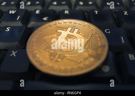 Coin Bitcoin or noir couché sur un clavier d'ordinateur. Concept de l'argent numérique. Banque D'Images