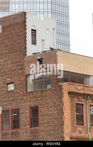 Ingénieur industriel descendre en rappel le long du côté d'un immeuble sur l'inspection des structures, New York City, USA Banque D'Images