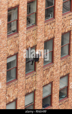 Ingénieur industriel descendre en rappel le long du côté d'un immeuble sur l'inspection des structures, New York City, USA Banque D'Images