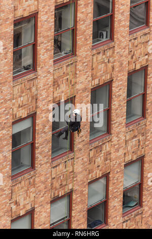 Ingénieur industriel descendre en rappel le long du côté d'un immeuble sur l'inspection des structures, New York City, USA Banque D'Images