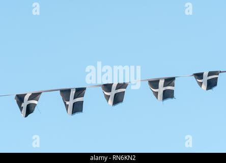 Cordes des cornouailles de Saint-Piran / drapeaux cornoueux flambants dans la brise un après-midi ensoleillé d'hiver. Drapeaux de groupage isolés du ciel bleu. Banque D'Images