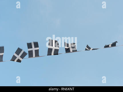 Cordes des cornouailles de Saint-Piran / drapeaux cornoueux flambants dans la brise un après-midi ensoleillé d'hiver. Drapeaux de groupage isolés du ciel bleu. Banque D'Images