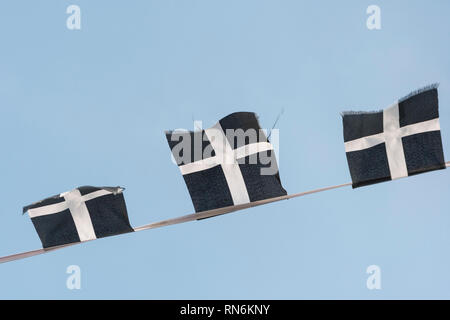 Cordes des cornouailles de Saint-Piran / drapeaux cornoueux flambants dans la brise un après-midi ensoleillé d'hiver. Drapeaux de groupage isolés du ciel bleu. Banque D'Images