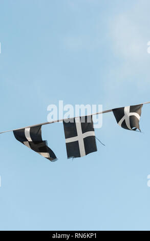 Cordes des cornouailles de Saint-Piran / drapeaux cornoueux flambants dans la brise un après-midi ensoleillé d'hiver. Drapeaux de groupage isolés du ciel bleu. Banque D'Images