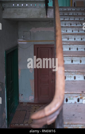 Deux portes dans un immeuble délabré avec un un escalier en bois menant à d'autres étages. Banque D'Images