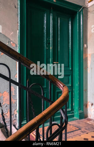 Escalier d'époque pour un bloc d'appartement menant à une porte verte Banque D'Images