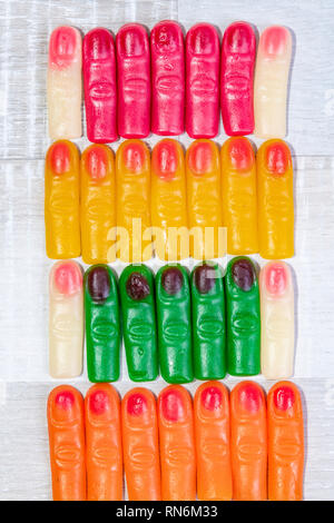 Couleur de motif en forme de doigt jelly sweets isolé sur un fond en bois clair. Banque D'Images