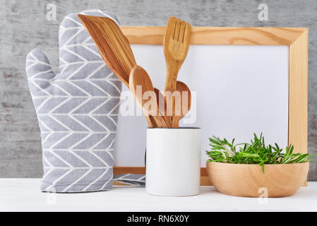 Des ustensiles de cuisine avec arrière-plan blanc vide, papier et couverts en bois manique sur table blanc Banque D'Images