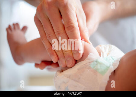 Photo des mains d'un massothérapeute faire massage des pieds pour petit enfant/ Banque D'Images