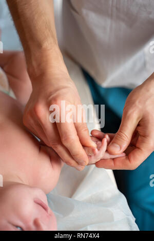 Image de mains de masseur et bébé sur la table de massage. Banque D'Images