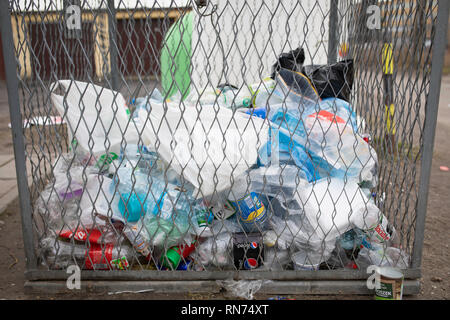 Conteneur de déchets en plastique. Déchets, ordures, mess, des bouteilles sur le sol. Gniezno / Pologne Banque D'Images