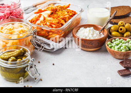 Les aliments probiotiques arrière-plan. Le kimchi, betterave choucroute, choucroute, fromage cottage, olives, pain, chocolat, le kéfir et concombres dans des bocaux en verre, Banque D'Images