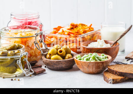 Les aliments probiotiques arrière-plan. Le kimchi, betterave choucroute, choucroute, fromage cottage, olives, pain, chocolat, le kéfir et concombres dans des bocaux en verre, Banque D'Images