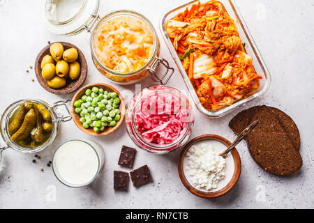 Les aliments probiotiques arrière-plan. Le kimchi, betterave choucroute, choucroute, fromage cottage, olives, pain, chocolat, le kéfir et concombres dans des bocaux en verre, Banque D'Images