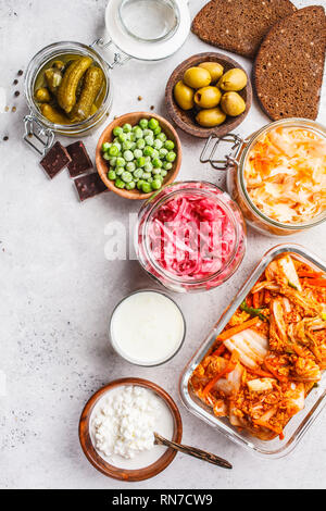 Les aliments probiotiques arrière-plan. Le kimchi, betterave choucroute, choucroute, fromage cottage, olives, pain, chocolat, le kéfir et concombres dans des bocaux en verre, Banque D'Images