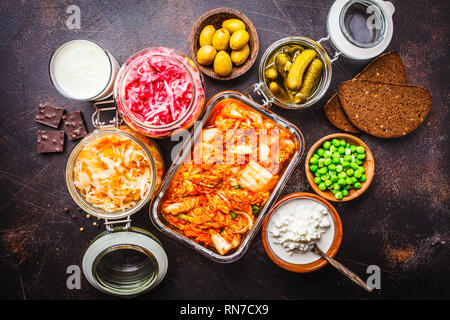 Les aliments probiotiques arrière-plan. Le kimchi, betterave choucroute, choucroute, fromage cottage, olives, pain, chocolat, le kéfir et concombres dans des bocaux en verre, Banque D'Images