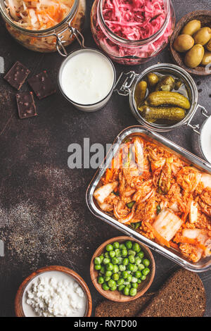 Les aliments probiotiques arrière-plan. Le kimchi, betterave choucroute, choucroute, fromage cottage, olives, pain, chocolat, le kéfir et concombres dans des bocaux en verre, Banque D'Images