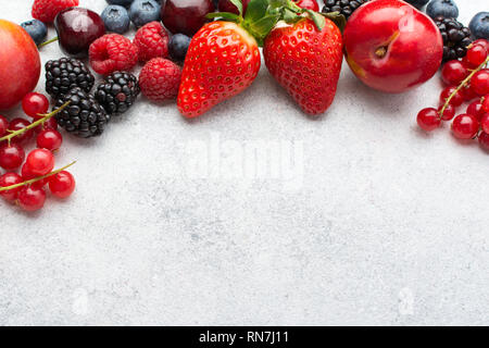 Arrière-plan baies colorées. Les bleuets fraises framboises mûres de groseille rouge, vue du dessus sur le tableau blanc, selective focus Banque D'Images