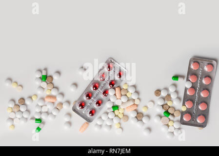 De nombreux médicaments colorés. Comprimés et gélules, seringue blister sur fond blanc. Vue supérieure avec copie espace, mise à plat. Banque D'Images