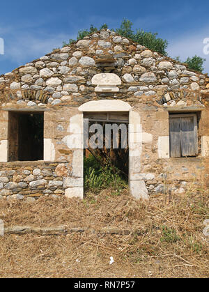 Détail de construction de portes et fenêtres sur mur de pierre dans le Magne Grèce avec sybols ouverture de porte ci-dessus . Sous ciel bleu profond. Banque D'Images