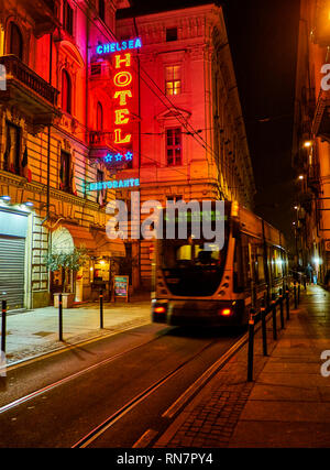 Turin, Italie - 1 janvier 2019. Hotel Ristorante et enseigne au néon dans une rue la nuit traversée par un bus urbain. Turin, Piémont, Italie. Banque D'Images