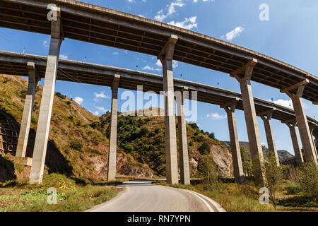 Route asphaltée dans les montagnes passe sous un pont routier, Chine Banque D'Images