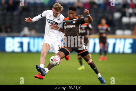 Swansea City's Oliver McBurnie (à gauche) et du Brentford Julian Jeanvier bataille pour la balle au cours de la FA Cup cinquième match au Liberty Stadium, Swansea. Banque D'Images