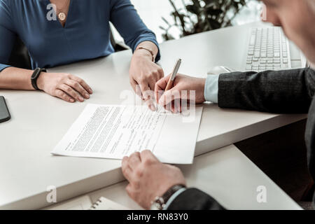 Femme avec une montre sur sa main indique le lieu à la signature de l'employé Banque D'Images