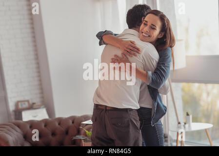 Enfin ensemble. Les jeunes de la famille adorable enlacés tout en exprimant l'optimisme et de vivre des émotions lumineuses Banque D'Images