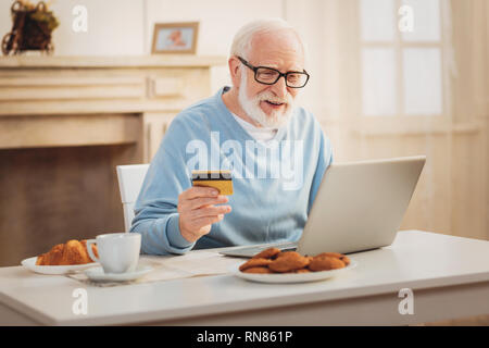 Qui effectue l'opération. Personnes âgées l'homme moderne se sentir impliqués dans la conduite d'opération tout en payant pour l'assurance santé mensuel Banque D'Images