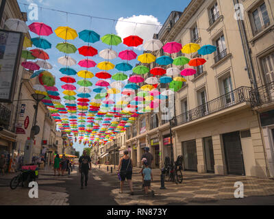 /Arc-en-ciel les parasols multicolores suspendues sur une rue pavée à Saumur, Loire, France. Banque D'Images