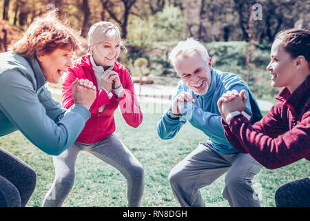 Exercices du matin. Groupe des retraités actifs à la table et à faire des exercices du matin Banque D'Images