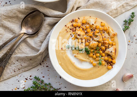 Chou-fleur rôti maison et pois chiche Soupe dans des bols sur fond de béton gris clair. L'alimentation végétarienne saine. Vue d'en haut.