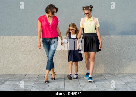 Mère et fille se tenant la main les élèves vont à l'école. Retour à l'école ! Banque D'Images