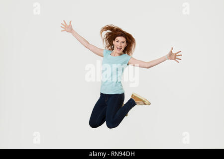 Happy active jeune femme sautant dans l'air des cris de joie Banque D'Images