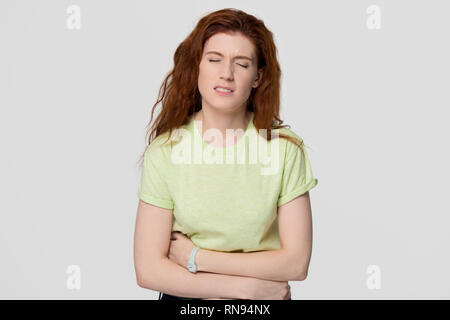 Femme rousse contrariée malades sentiment d'estomac holding belly Banque D'Images