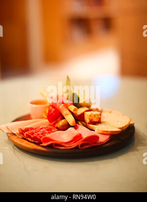 Mélange de jambon espagnol traditionnel de salami, de jambon de parme sur grissini bâtonnets de pain, légumes marinés et olives sur plaque en bois avec décor rustique. Nuit pa Banque D'Images