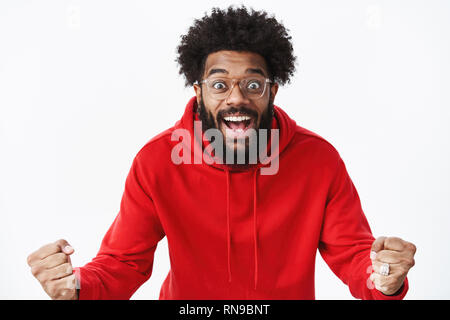 Studio shot of surpris et ravis african american guy work dans la joie et l'émerveillement des yeux popping et souriant heureux réagir à Banque D'Images