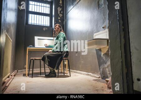 Berlin, Allemagne. Feb 18, 2019. Sandra Scheeres (SPD) de Berlin, le sénateur de l'éducation, s'informe sur l'histoire de la chambre à l'ouverture d'un lieu d'apprentissage parascolaires dans une cellule de l'ex-RDA Berlin police prison Keibelstraße. Selon le sénateur, jeunes il sera en mesure de traiter l'état d'arbitraire et de la répression dans la RDA à l'avenir. Visites guidées de l'édifice sont également prévues pour les visiteurs intéressés. La prison était vide depuis des années, l'utilisation avait été mal pendant une longue période. Credit : Jörg Carstensen/dpa/Alamy Live News Banque D'Images