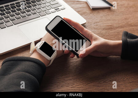 Portrait de femme avec smartwatch, smartphone et ordinateur portable Banque D'Images