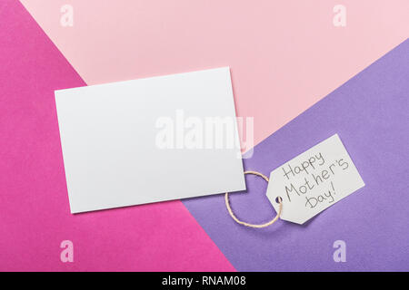 Carte postale vierge blanc et étiquette en papier avec happy mothers day texte d'accueil sur fond tricolore Banque D'Images