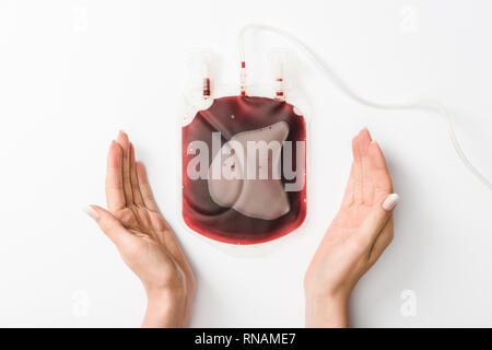 Portrait de femme tenant avec goutte de sang sur fond blanc, concept de don du sang Banque D'Images