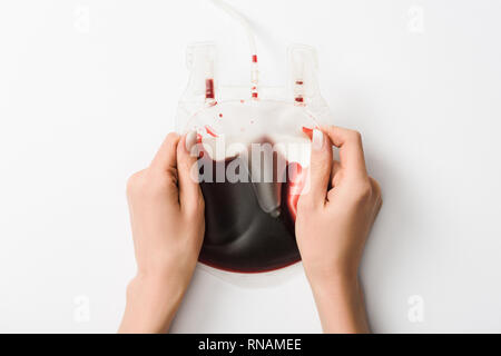 Vue partielle de la femme tenant avec du sang goutte sur fond blanc, concept de don du sang Banque D'Images