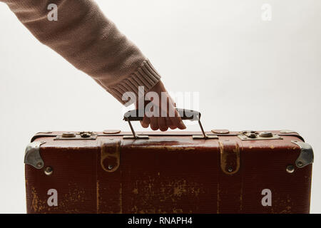 Portrait of woman holding brown suitcase isolé sur gray Banque D'Images