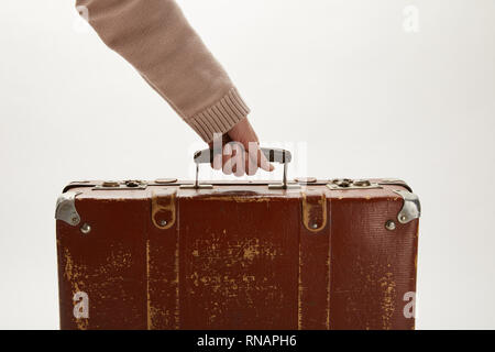 Vue partielle de woman holding brown suitcase isolé sur gray Banque D'Images