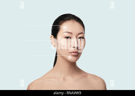 Portrait of Asian Spa jeune, belle et naturelle femme avec des flèches en pointillés sur son visage sur fond bleu. Médecine et soins de la peau Banque D'Images