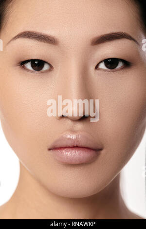 Close-up portrait of beautiful young asian woman on white background libre. fille avec la peau propre. Procédé d'augmentation après lèvres femelle Banque D'Images